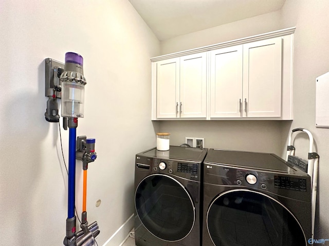 clothes washing area featuring cabinets and independent washer and dryer