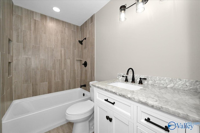 full bathroom featuring tiled shower / bath, hardwood / wood-style flooring, vanity, and toilet