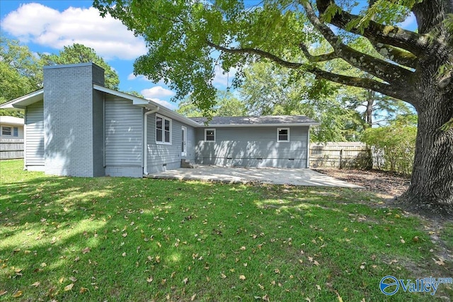 rear view of house featuring a lawn and a patio