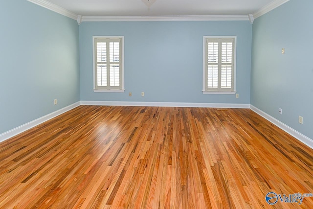 empty room featuring baseboards, ornamental molding, and wood finished floors