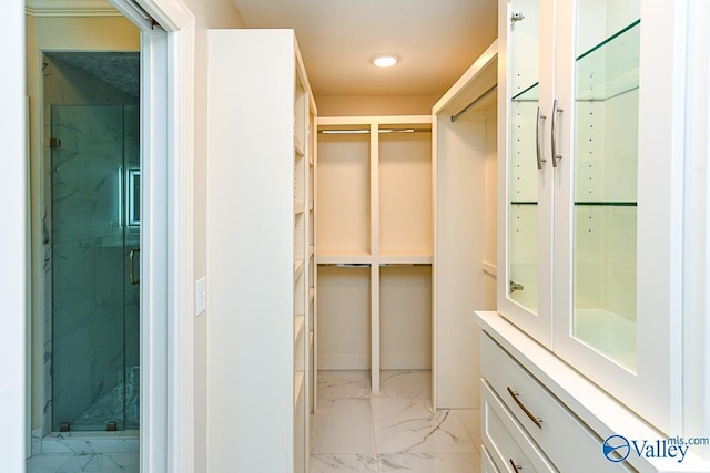 walk in closet with marble finish floor