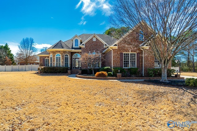 view of front of home with fence and brick siding