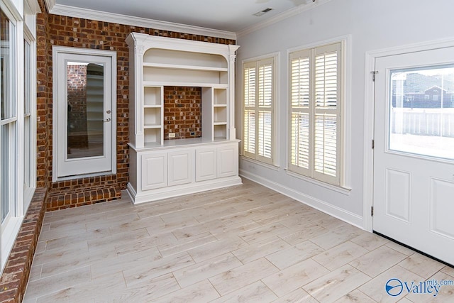 interior space featuring light wood finished floors, crown molding, visible vents, and a wealth of natural light