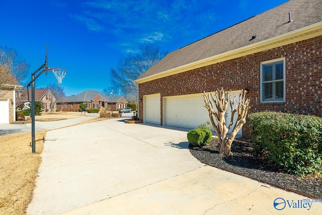 view of property exterior with driveway, a shingled roof, a residential view, and brick siding