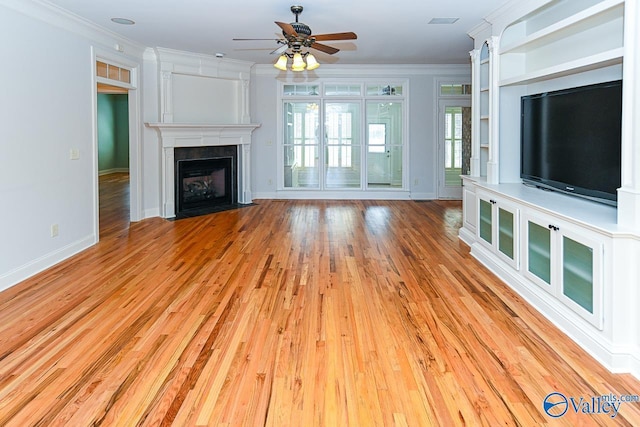 unfurnished living room with baseboards, a fireplace with flush hearth, ceiling fan, ornamental molding, and light wood-type flooring