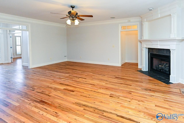 unfurnished living room with ornamental molding, a large fireplace, and light wood finished floors