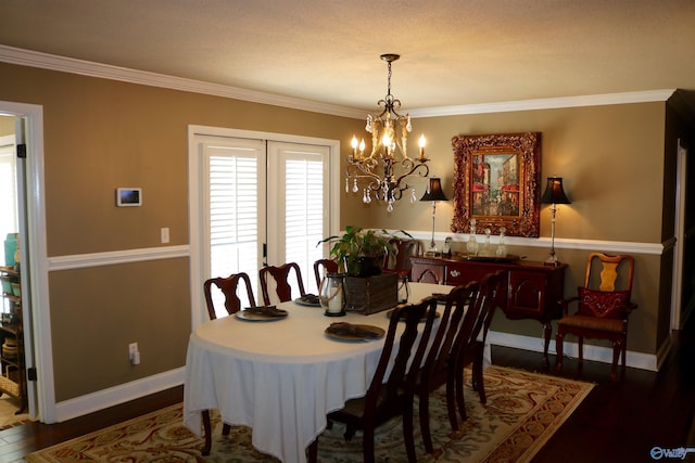 dining room featuring a notable chandelier, crown molding, dark wood-type flooring, and baseboards