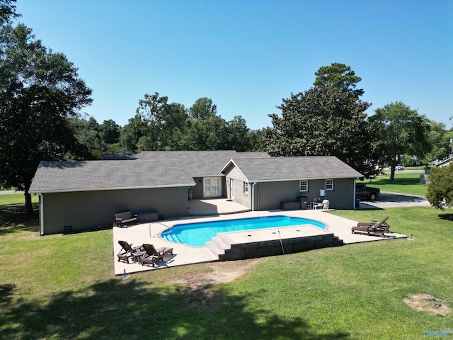 view of pool with a patio and a lawn