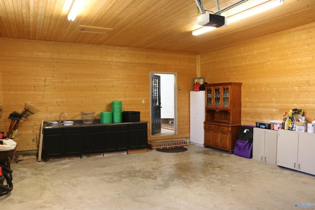 garage with wooden walls, a garage door opener, and wooden ceiling
