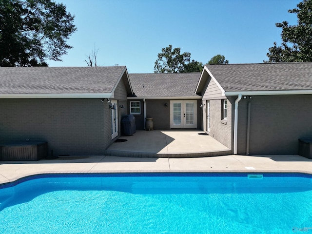 outdoor pool with a patio, french doors, and grilling area