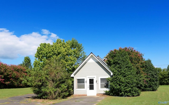view of property hidden behind natural elements with a front yard