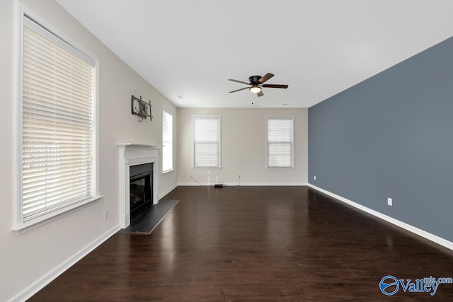 unfurnished living room with ceiling fan and dark hardwood / wood-style flooring