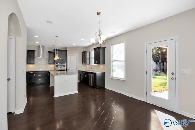 217 Skehan St SW, Huntsville, AL 35824 - kitchen with wall chimney exhaust hood, backsplash, dark wood-style flooring, a center island, and a chandelier