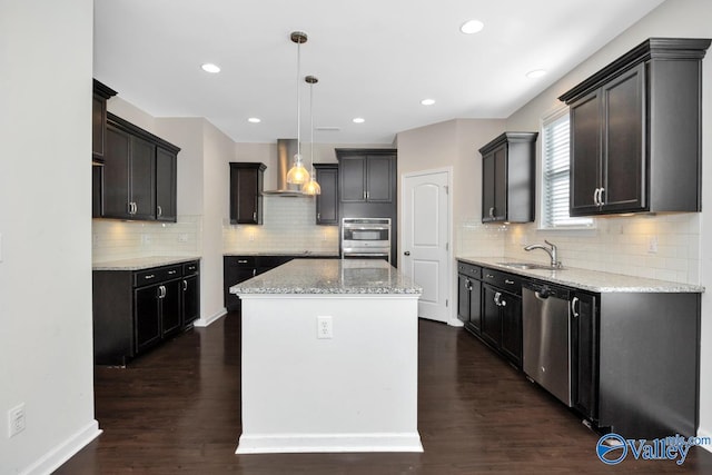 kitchen featuring stainless steel appliances, dark hardwood / wood-style flooring, hanging light fixtures, wall chimney range hood, and a kitchen island