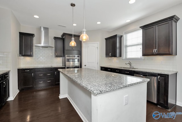 217 Skehan St SW, Huntsville, AL 35824 - kitchen with wall chimney range hood, appliances with stainless steel finishes, a kitchen island, tasteful backsplash, and recessed lighting