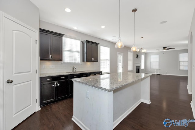 217 Skehan St SW, Huntsville, AL 35824 - kitchen with ceiling fan, a center island, decorative light fixtures, light stone counters, and dark wood-style floors