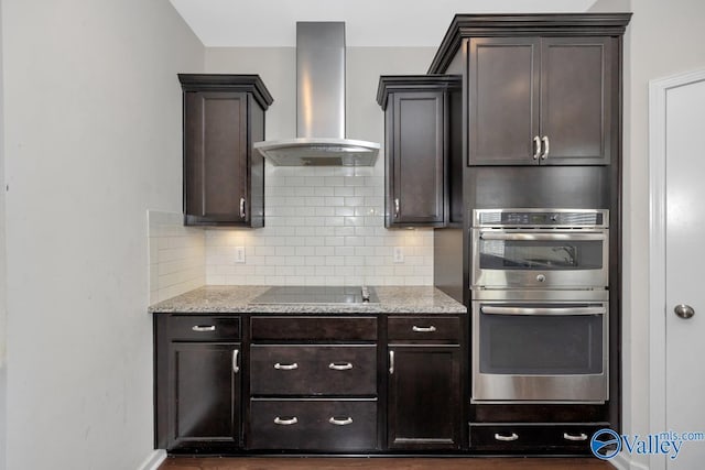 217 Skehan St SW, Huntsville, AL 35824 - kitchen with wall chimney exhaust hood, stainless steel double oven, black electric stovetop, and dark brown cabinets