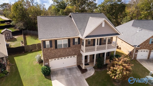 view of front property featuring a balcony, a front yard, and a garage