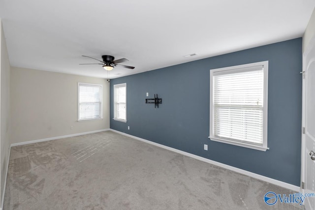 carpeted spare room with ceiling fan