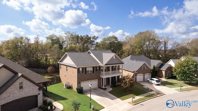217 Skehan St SW, Huntsville, AL 35824 - view of front of house with concrete driveway, a balcony, an attached garage, a residential view, and brick siding
