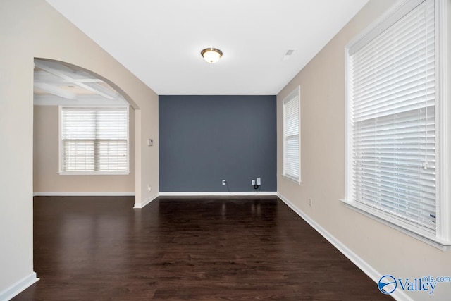 empty room with dark hardwood / wood-style floors, beam ceiling, and coffered ceiling