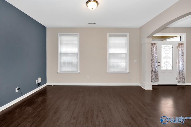 entryway with a wealth of natural light and dark hardwood / wood-style flooring