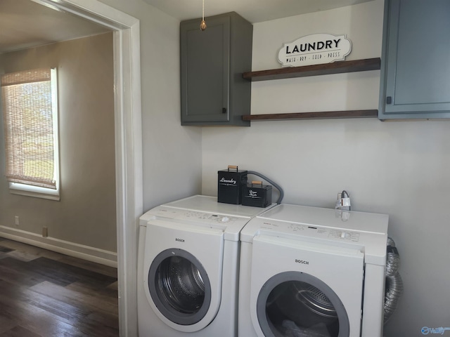 clothes washing area with separate washer and dryer, baseboards, wood finished floors, and cabinet space
