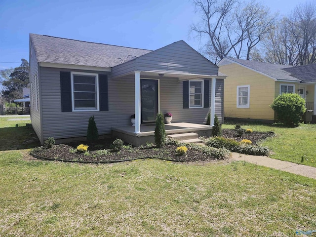 bungalow-style house featuring roof with shingles, a front yard, and a porch