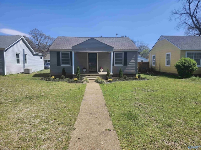 bungalow-style house featuring a shingled roof, central AC unit, a front lawn, and covered porch
