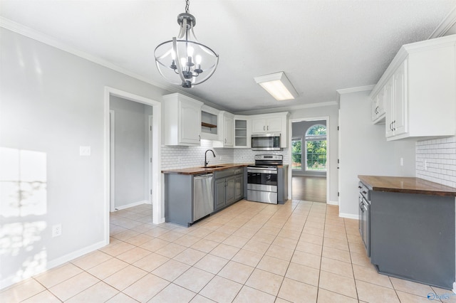 123 Turtle Ridge Dr, New Market, AL 35761 - kitchen featuring stainless steel appliances, butcher block countertops, a sink, backsplash, and ornamental molding