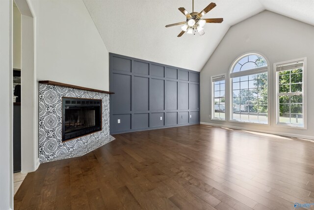123 Turtle Ridge Dr, New Market, AL 35761 - unfurnished living room with ceiling fan, high vaulted ceiling, wood finished floors, a tile fireplace, and a decorative wall