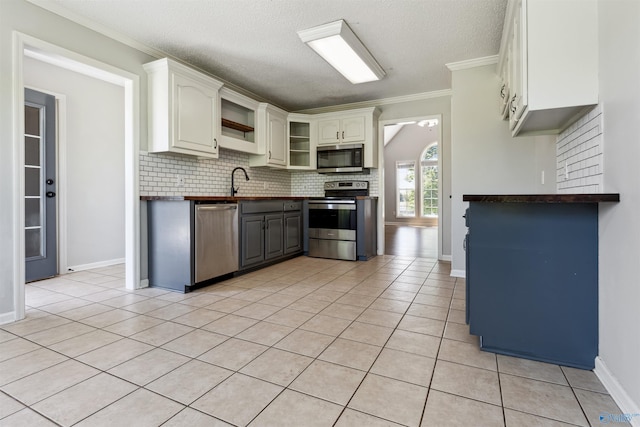 123 Turtle Ridge Dr, New Market, AL 35761 - kitchen featuring stainless steel appliances, dark countertops, open shelves, decorative backsplash, and ornamental molding