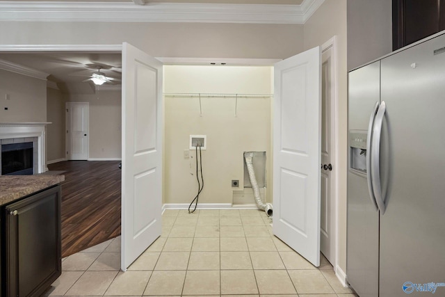 kitchen featuring ceiling fan, light tile patterned floors, a fireplace, stainless steel fridge with ice dispenser, and crown molding