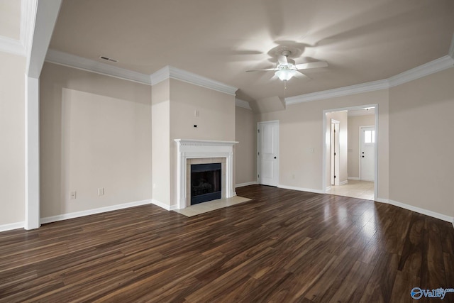 unfurnished living room featuring baseboards, a ceiling fan, wood finished floors, crown molding, and a fireplace