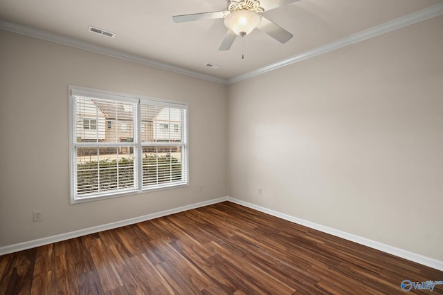 empty room featuring ornamental molding, dark wood finished floors, visible vents, and baseboards