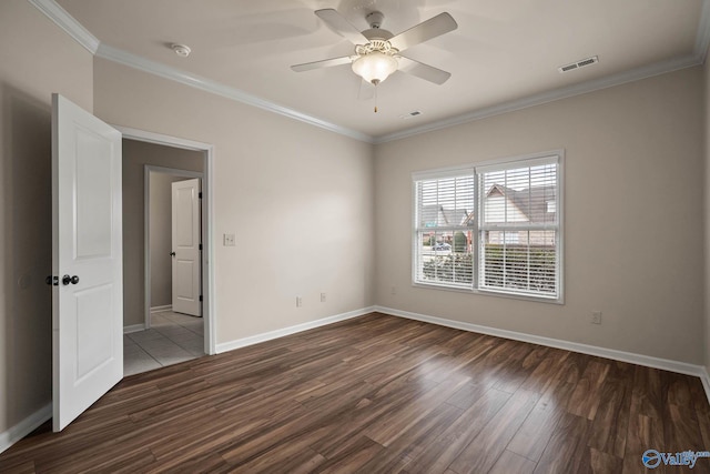 unfurnished room featuring visible vents, ornamental molding, ceiling fan, wood finished floors, and baseboards