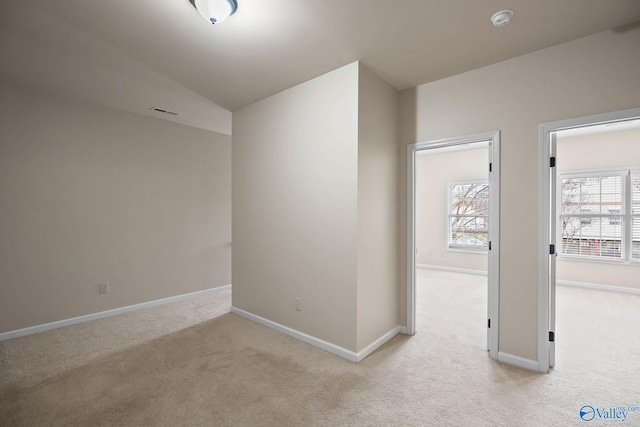 interior space with light carpet, visible vents, and baseboards