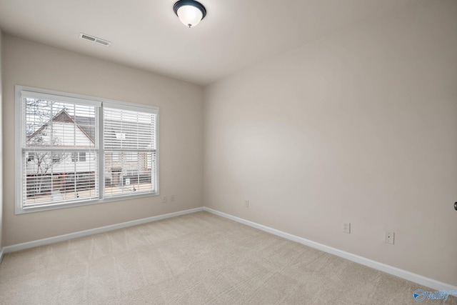 unfurnished room with visible vents, baseboards, and light colored carpet