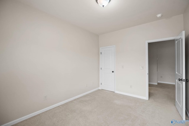 unfurnished bedroom with baseboards and light colored carpet