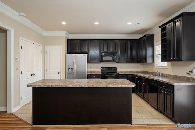 kitchen featuring black appliances, light tile patterned floors, a kitchen island, and a sink