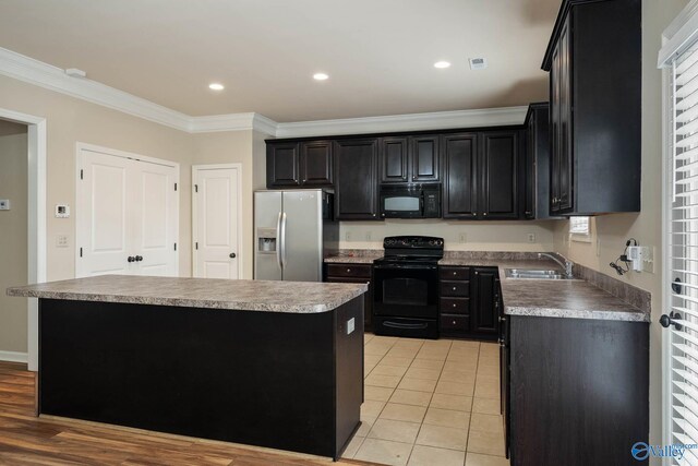 kitchen with crown molding, a kitchen island, a sink, dark cabinetry, and black appliances