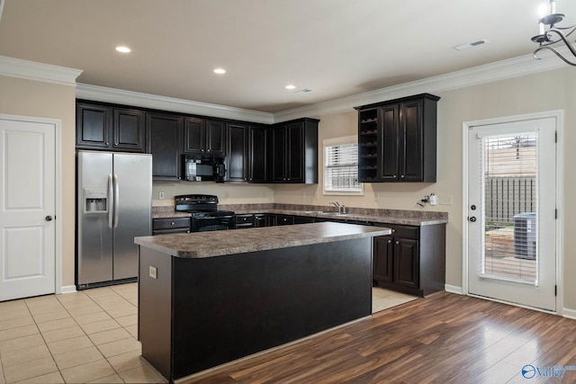 kitchen featuring black appliances, plenty of natural light, and dark cabinets