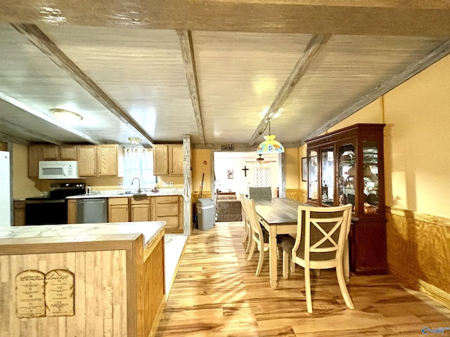 kitchen featuring light countertops, light wood-style flooring, wainscoting, light brown cabinets, and white appliances