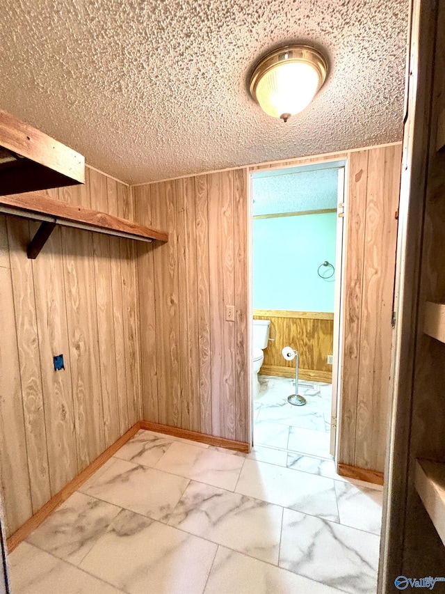 walk in closet with marble finish floor