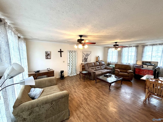 living room with a textured ceiling, wood finished floors, and a ceiling fan