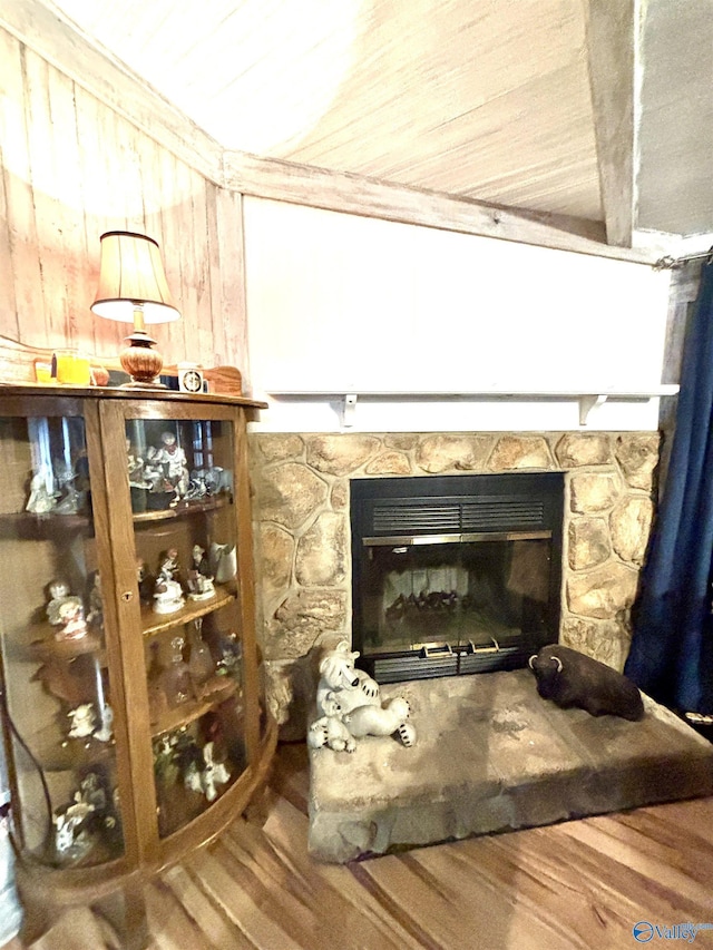 interior details featuring wood finished floors and a stone fireplace