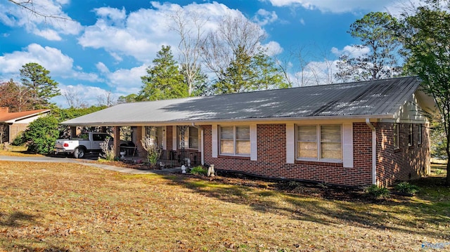 ranch-style house featuring a front lawn, a porch, and a carport