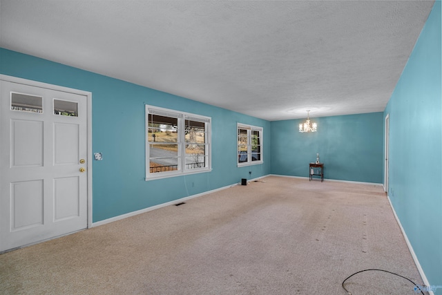 interior space with a chandelier, carpet, and a textured ceiling