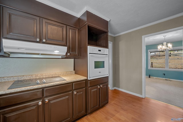 kitchen with an inviting chandelier, white oven, crown molding, light hardwood / wood-style floors, and black electric cooktop