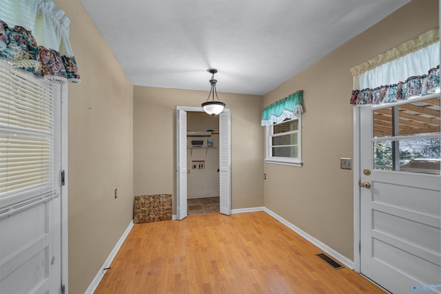 doorway to outside featuring wood-type flooring and a textured ceiling